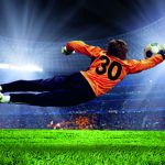 Football goalman on the stadium field