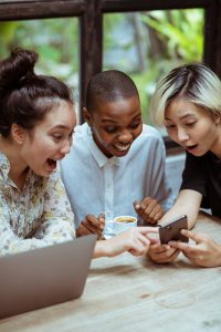 Youtube Seo: Drei Frauen schauen auf ein Handy