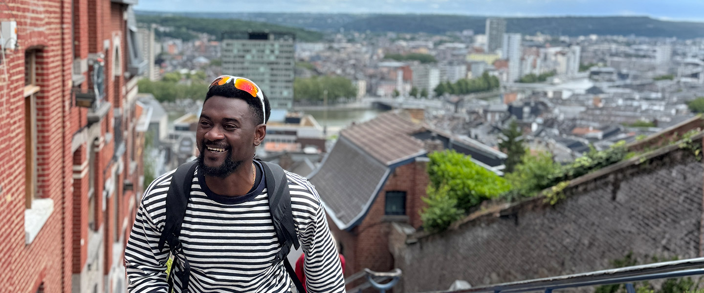 Kofi Baafi steigt eine Treppe in einer großen Stadt nach oben.