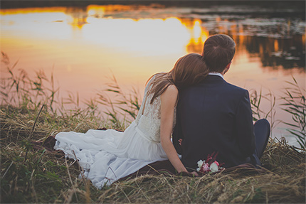 Hochzeitspaar am Wasser bei Sonnenuntergang