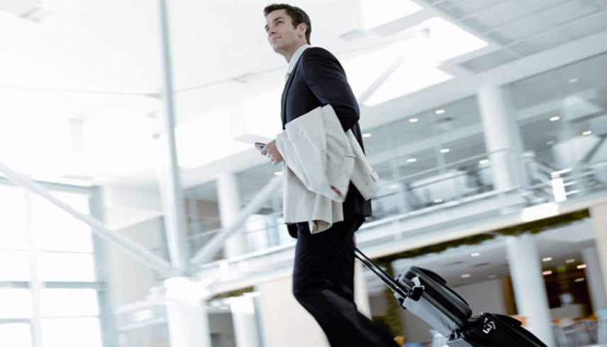 Mann mit Koffer im Flughafen