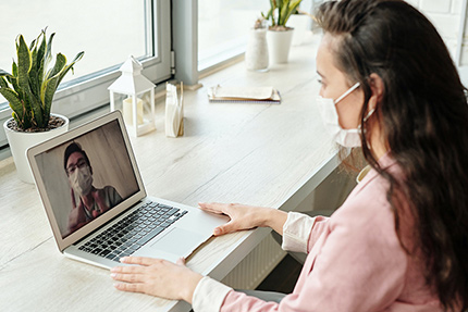 Frau aus dem Gesundheitswesen sitzt vor Laptop