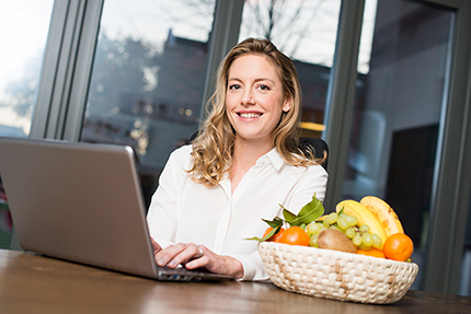 Frau im Homoffice mit Obstkorb