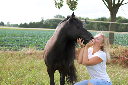 Frau küsst Pferd