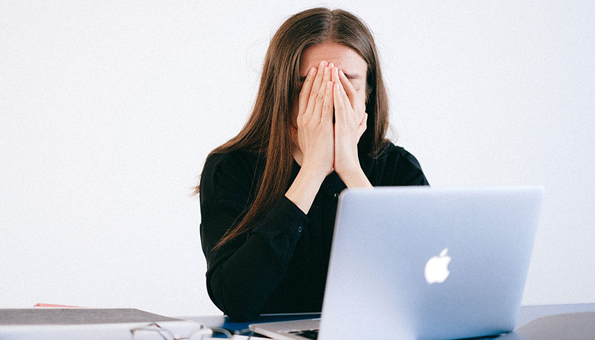 Frau gestresst vor Laptop
