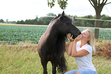 Frau küsst Pferd