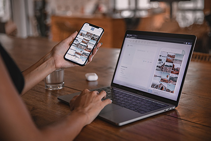 Persona arbeitet mit Laptop und Handy