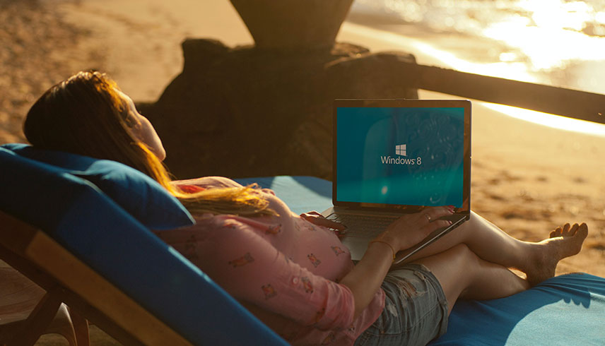 Frau am Strand mit Laptop