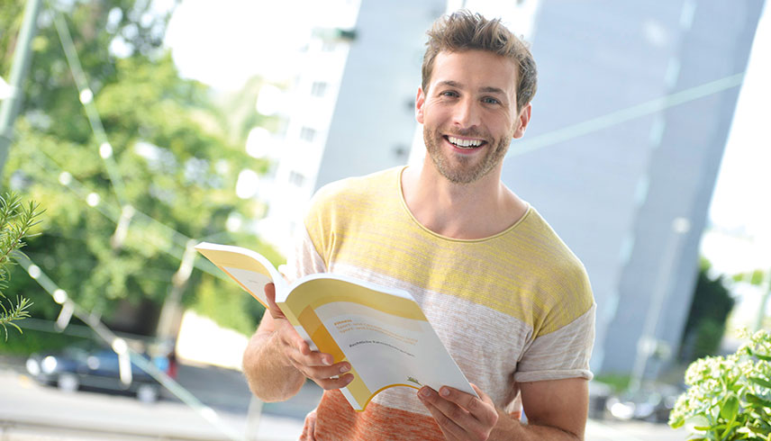 Dualer Student draußen mit Buch