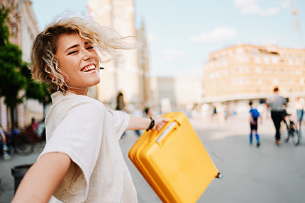 Reiseleiterin mit gelben Koffer
