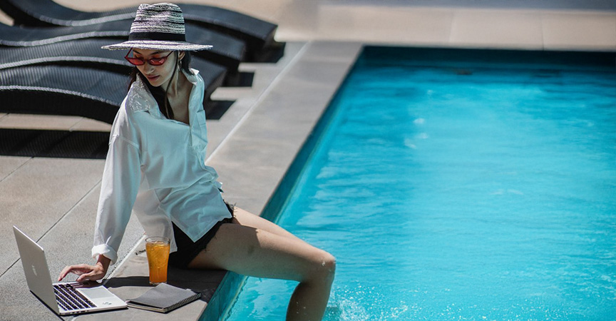 Frau am Pool mit Laptop
