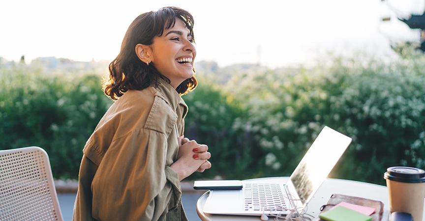 lachende Frau während Weiterbildung am Laptop