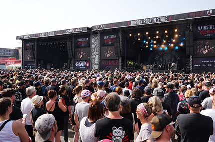 Besucher eines Festivals vor einer Bühne